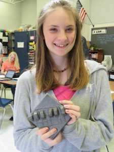 Student with the iron tile she created