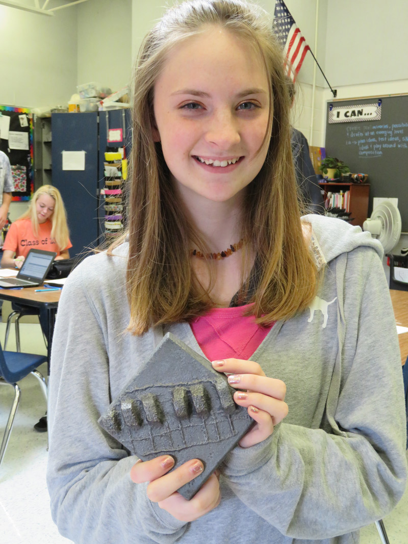 Student with the iron tile she created