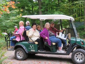 A group takes a golf cart tour at the Art Park